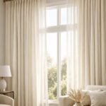 `Elegant cream linen no-sew curtains hung high and wide on a brass rod in a bright, modern living room.`
