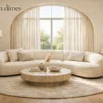 Modern 2026 living room layout featuring a curved cream bouclé sofa and a circular rug.